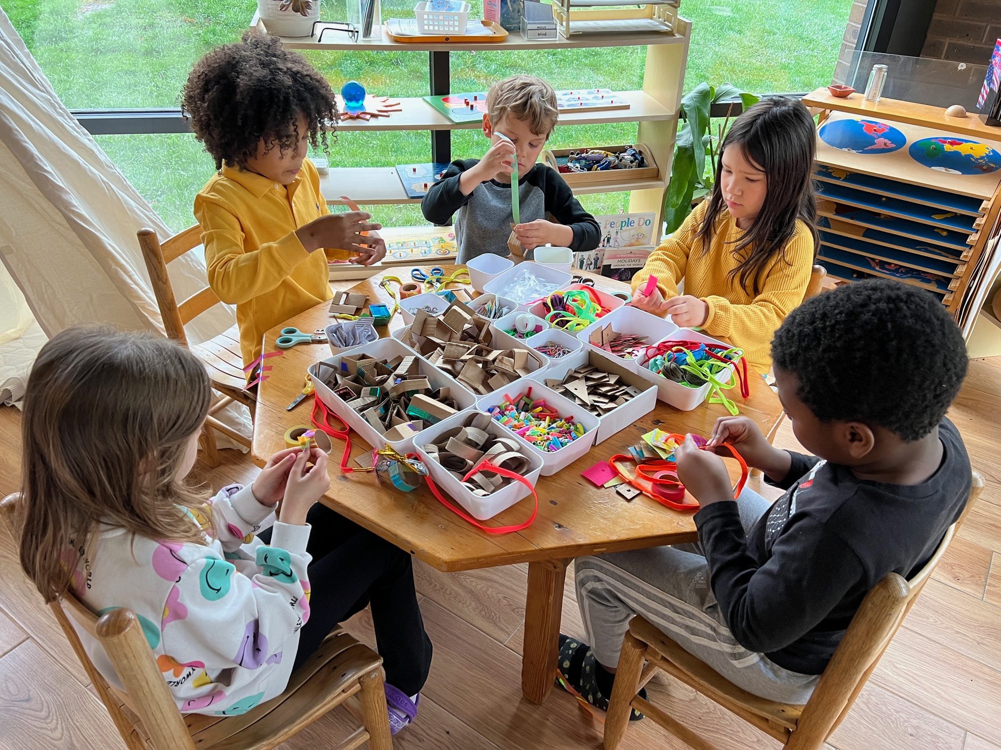 Children choosing from trays of open-ended materials
